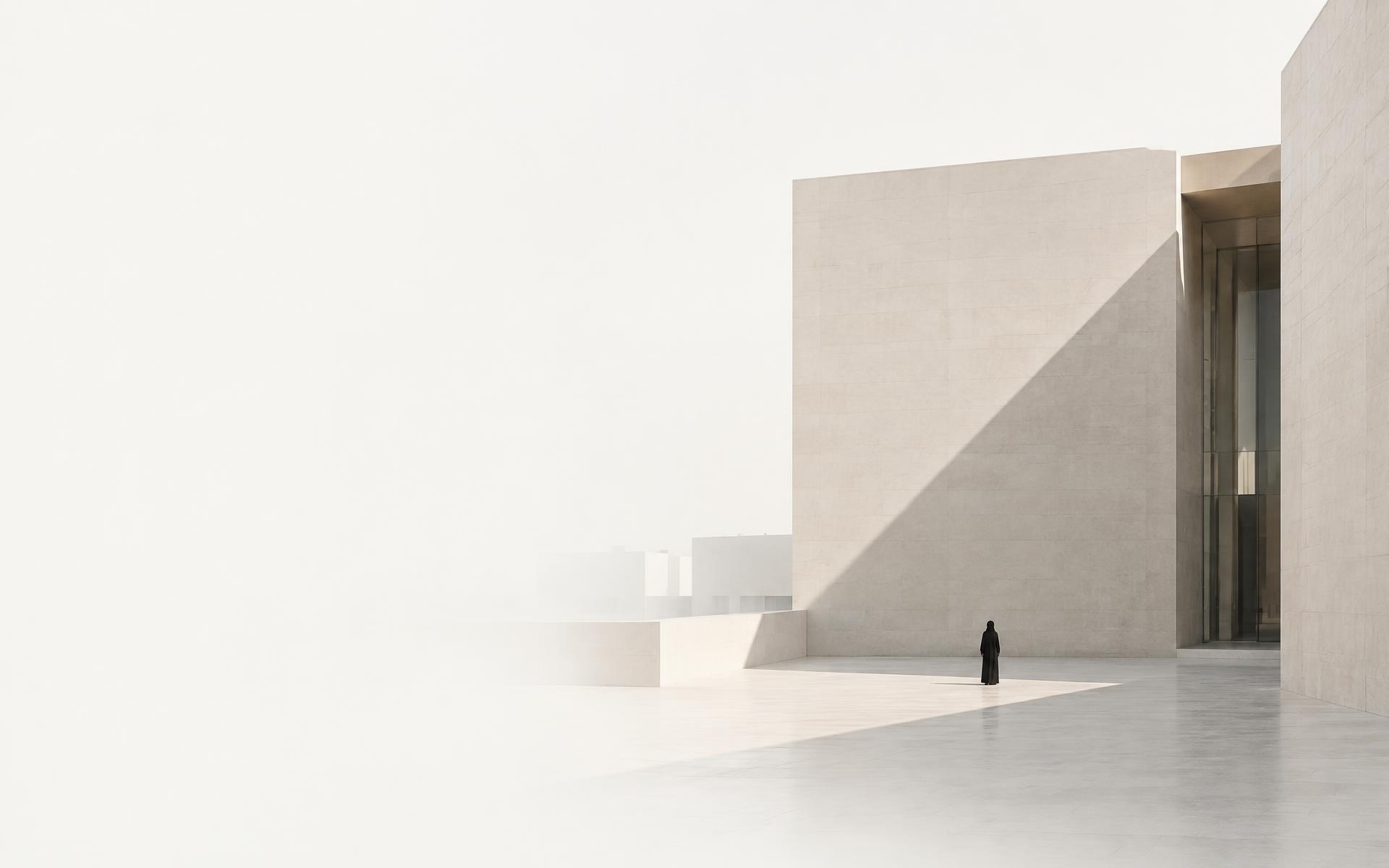 Pale concrete architecture in daylight, with a figure showing its scale